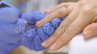 五金美甲，特写，美甲护理美妇在美容院.. 有清漆的美甲。 指甲治疗
